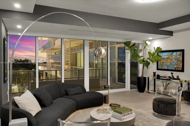 a living room with furniture a flat screen tv and a large window