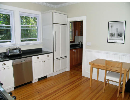 185 Rawson Road, Unit 3 Brookline, MA 02445 - Photo 3 of 18 a kitchen with granite countertop a refrigerator a sink and wooden cabinets