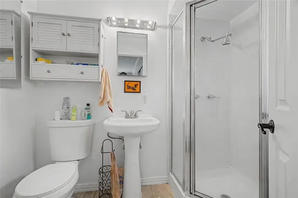 a bathroom with a sink a toilet and shower