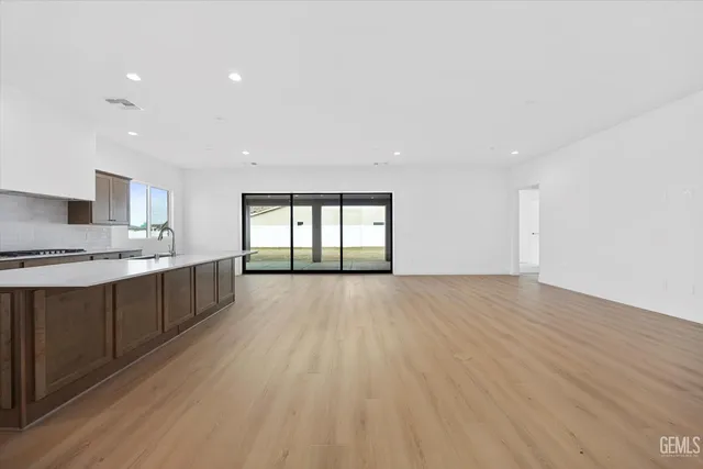 a large kitchen with a lot of cabinets and wooden floor
