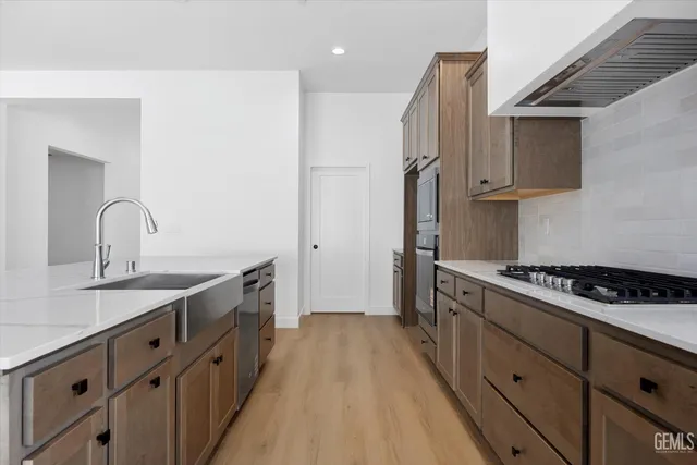 a kitchen with stainless steel appliances a sink stove and cabinets