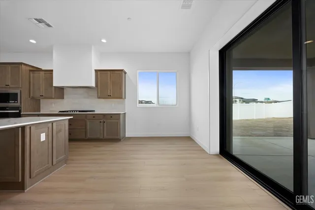 a large kitchen with a refrigerator and a stove top oven
