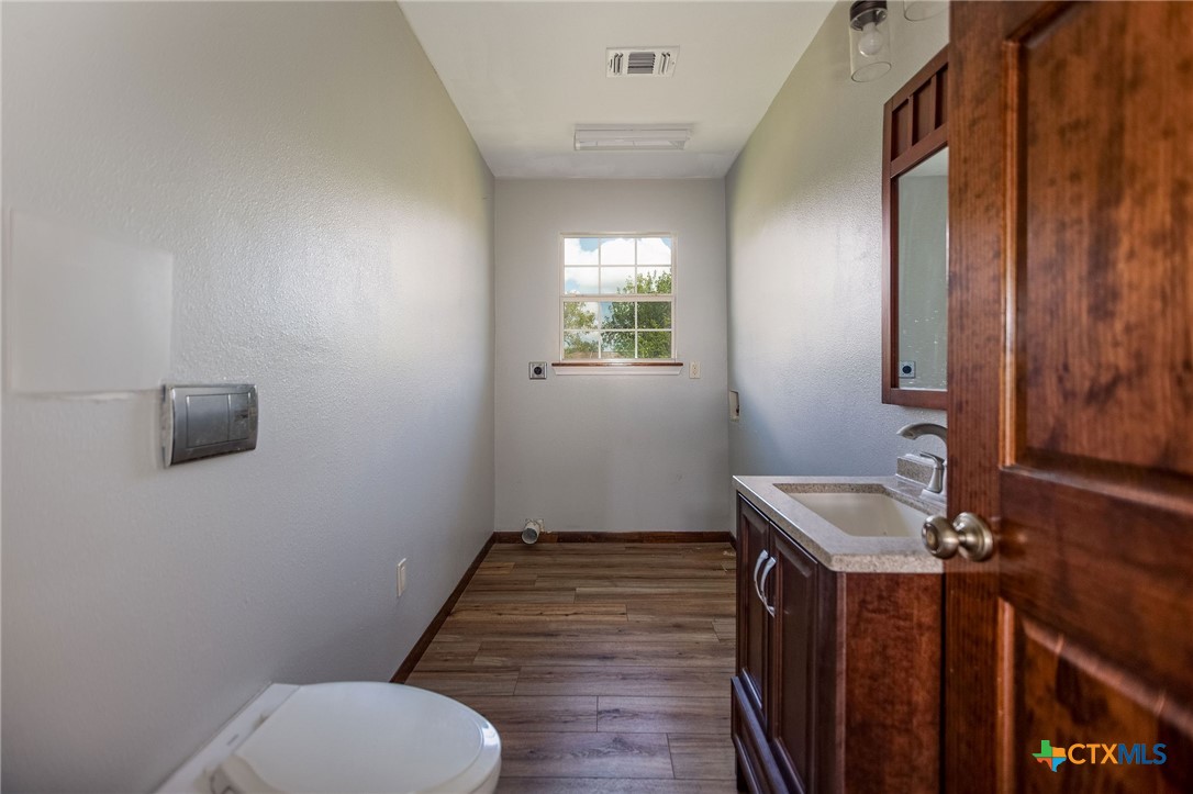 512 McDowell Street Austwell, TX 77950 - Photo 20 of 30 a bathroom with a toilet sink and mirror