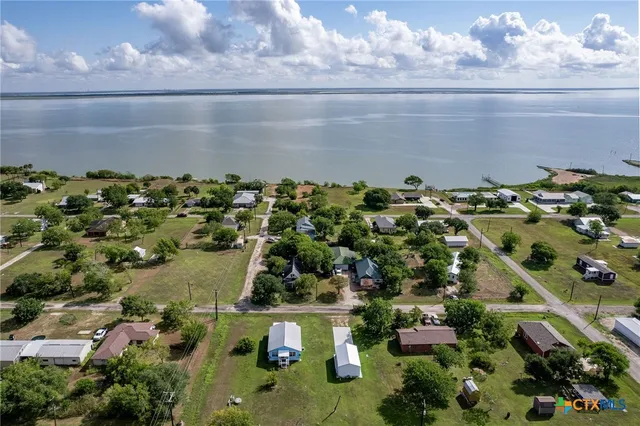 a kitchen with granite countertop wooden floors a refrigerator and a sink