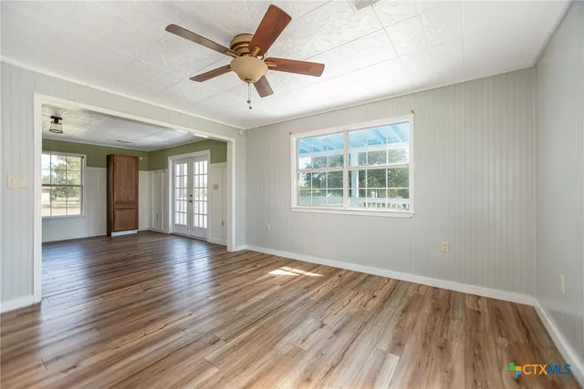 a view of a livingroom with wooden floor and a ceiling fan