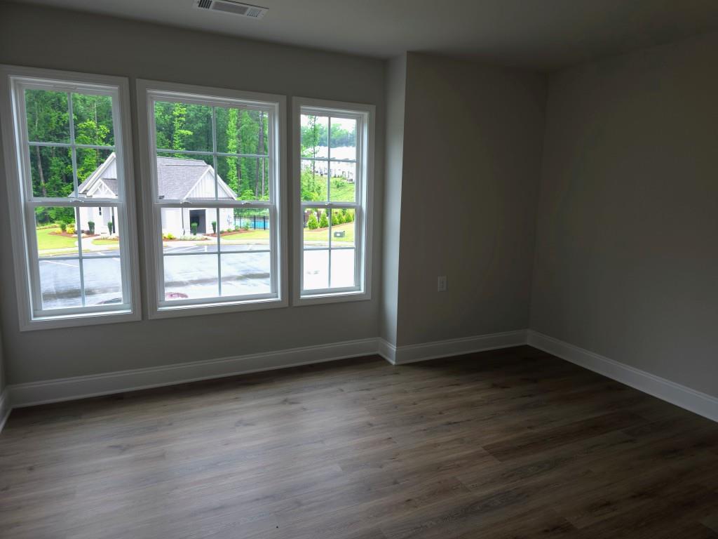 4240 Cavalier Way Duluth, GA 30097 - Photo 21 of 46 a view of an empty room with wooden floor and a window