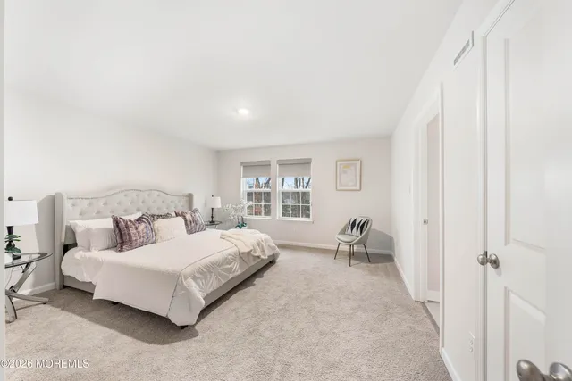 a spacious bedroom with a bed and chair