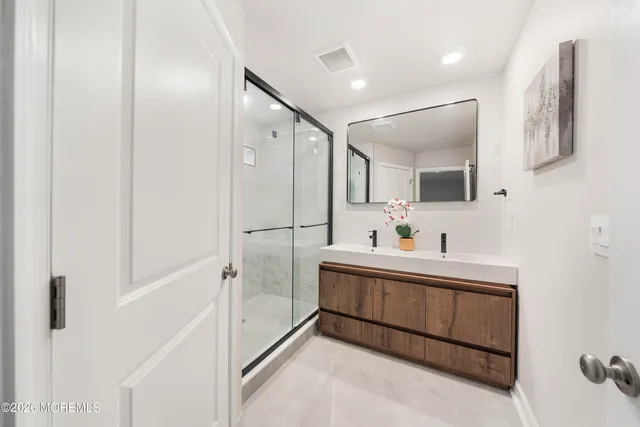a bathroom with a sink mirror and a shower