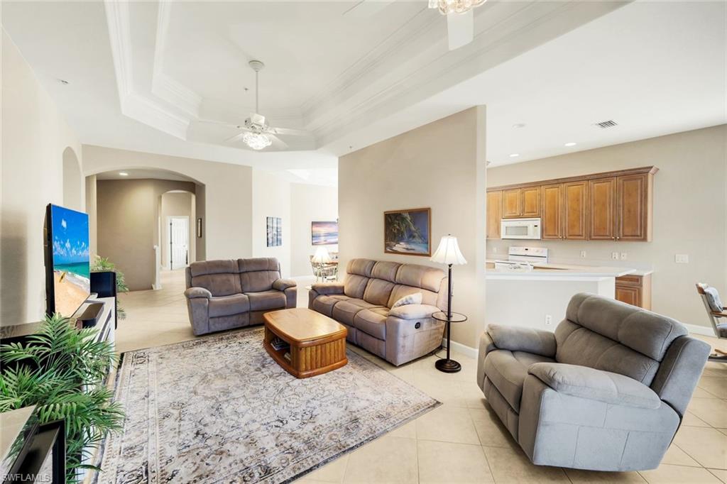 8771 Coastline Court, Unit 201 Naples, FL 34120 - Photo 11 of 49 a living room with furniture and a chandelier