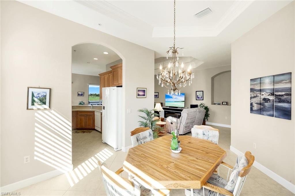 8771 Coastline Court, Unit 201 Naples, FL 34120 - Photo 13 of 49 a living room with dining table and a chandelier