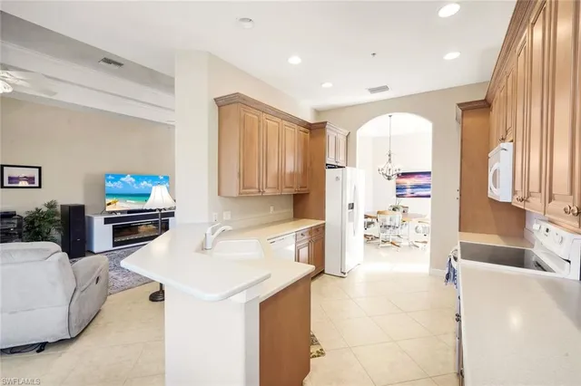 a kitchen with stainless steel appliances kitchen island granite countertop a sink and a refrigerator