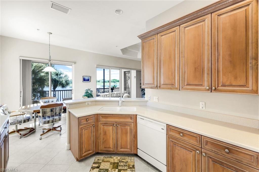 8771 Coastline Court, Unit 201 Naples, FL 34120 - Photo 16 of 49 a kitchen with a sink and cabinets