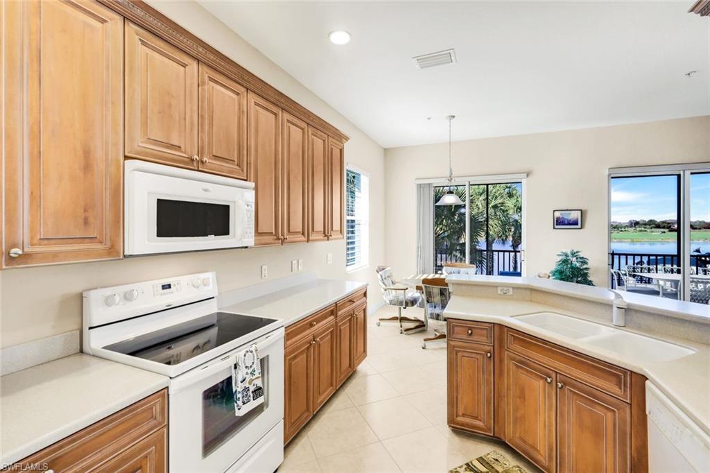 8771 Coastline Court, Unit 201 Naples, FL 34120 - Photo 17 of 49 a kitchen with a sink stove and microwave