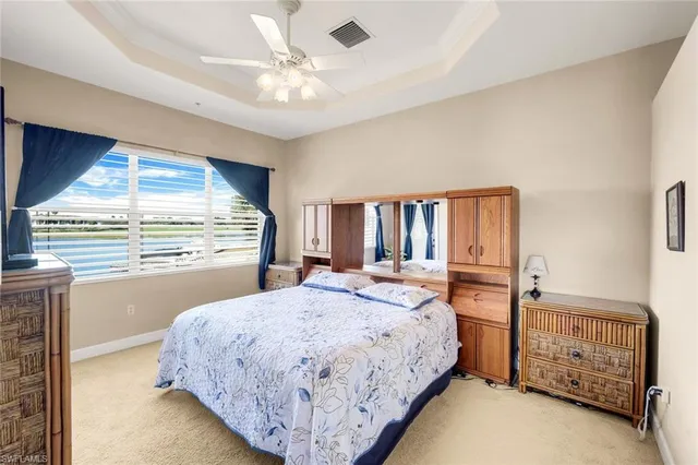 a spacious bedroom with a bed a window and dresser