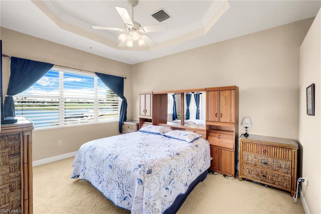 8771 Coastline Court, Unit 201 Naples, FL 34120 - Photo 20 of 49 a spacious bedroom with a bed a window and dresser