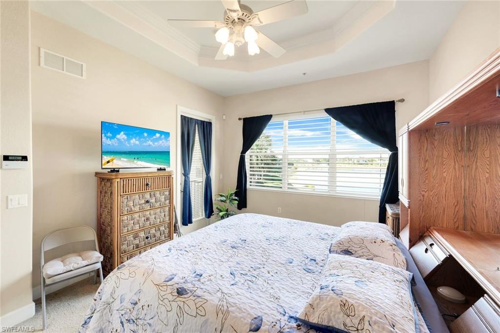 8771 Coastline Court, Unit 201 Naples, FL 34120 - Photo 21 of 49 a bedroom with a bed and a window