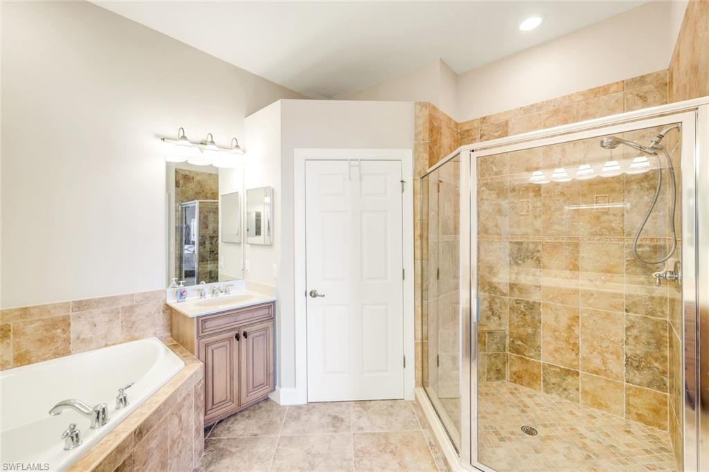 8771 Coastline Court, Unit 201 Naples, FL 34120 - Photo 22 of 49 a bathroom with a tub sink and shower