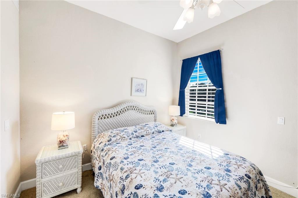 8771 Coastline Court, Unit 201 Naples, FL 34120 - Photo 23 of 49 a bedroom with a bed and a window