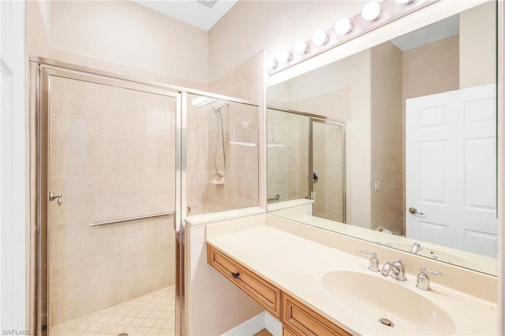 8771 Coastline Court, Unit 201 Naples, FL 34120 - Photo 25 of 49 a bathroom with a sink and a mirror