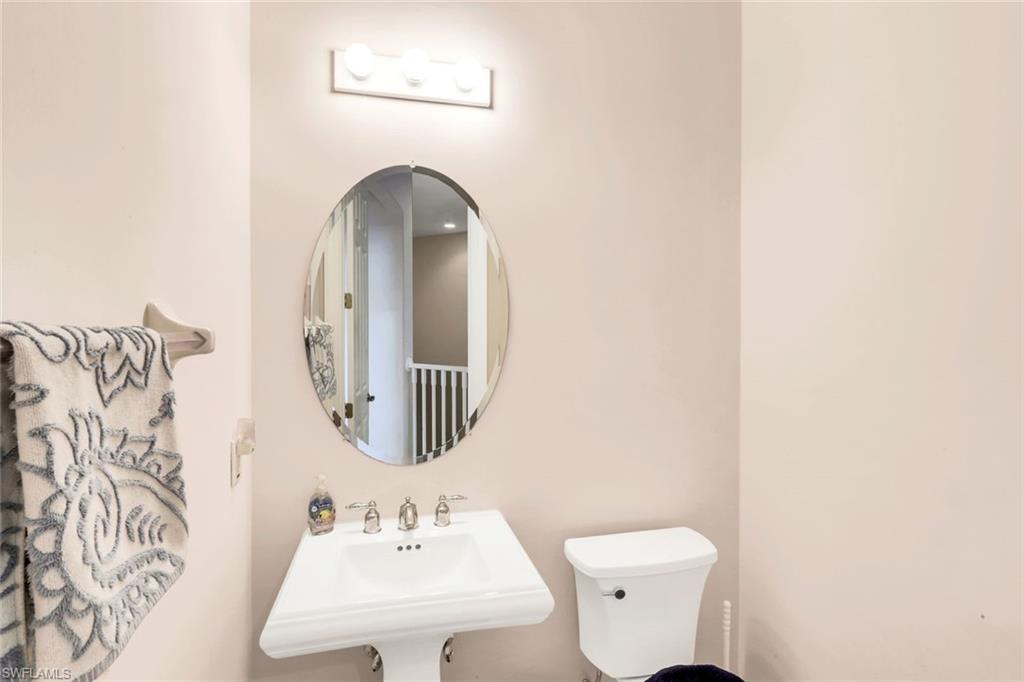8771 Coastline Court, Unit 201 Naples, FL 34120 - Photo 28 of 49 a bathroom with a toilet sink and mirror