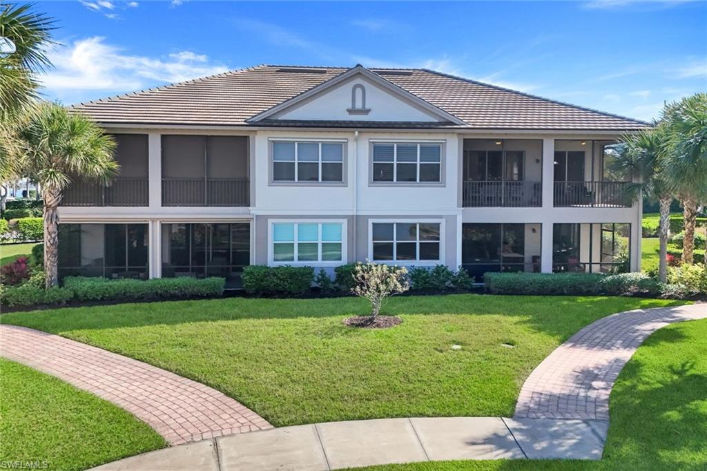 8771 Coastline Court, Unit 201 Naples, FL 34120 - Photo 33 of 49 a front view of a house with a yard