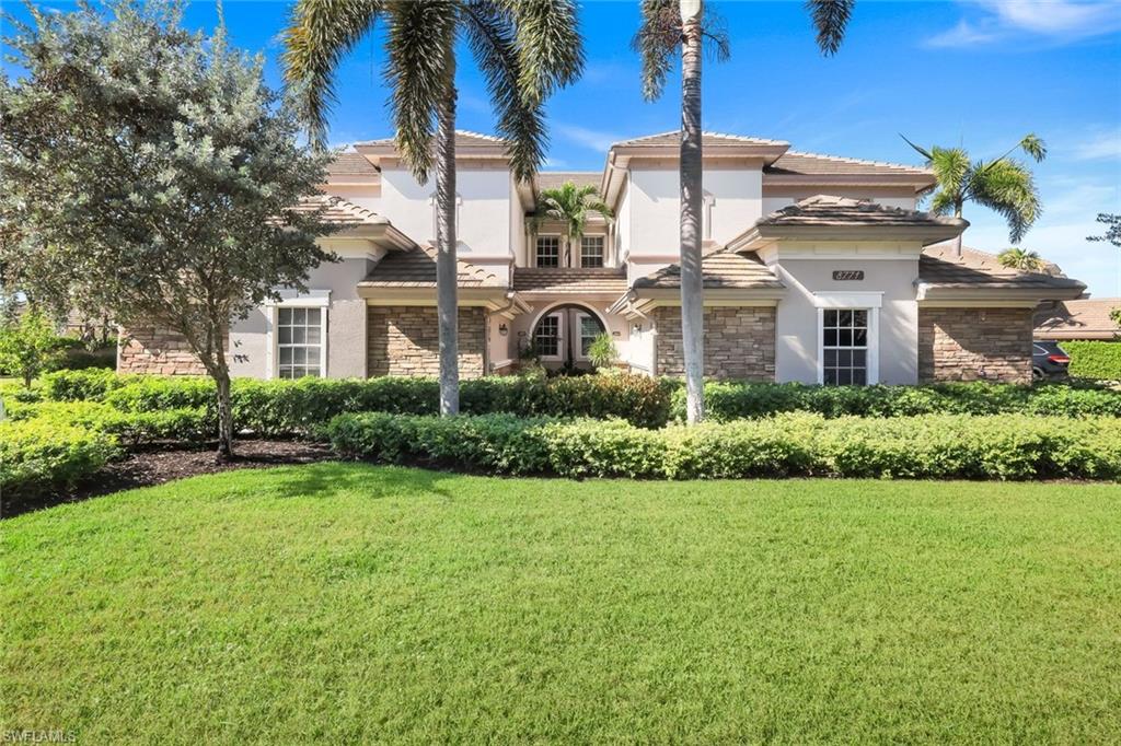 8771 Coastline Court, Unit 201 Naples, FL 34120 - Photo 7 of 49 a front view of a house with a yard