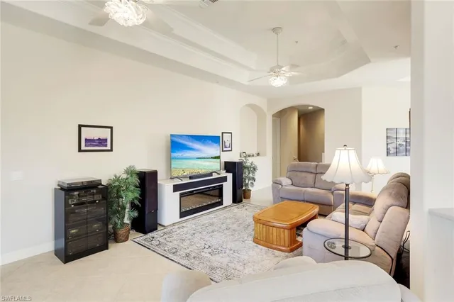 a living room with furniture a chandelier and a flat screen tv