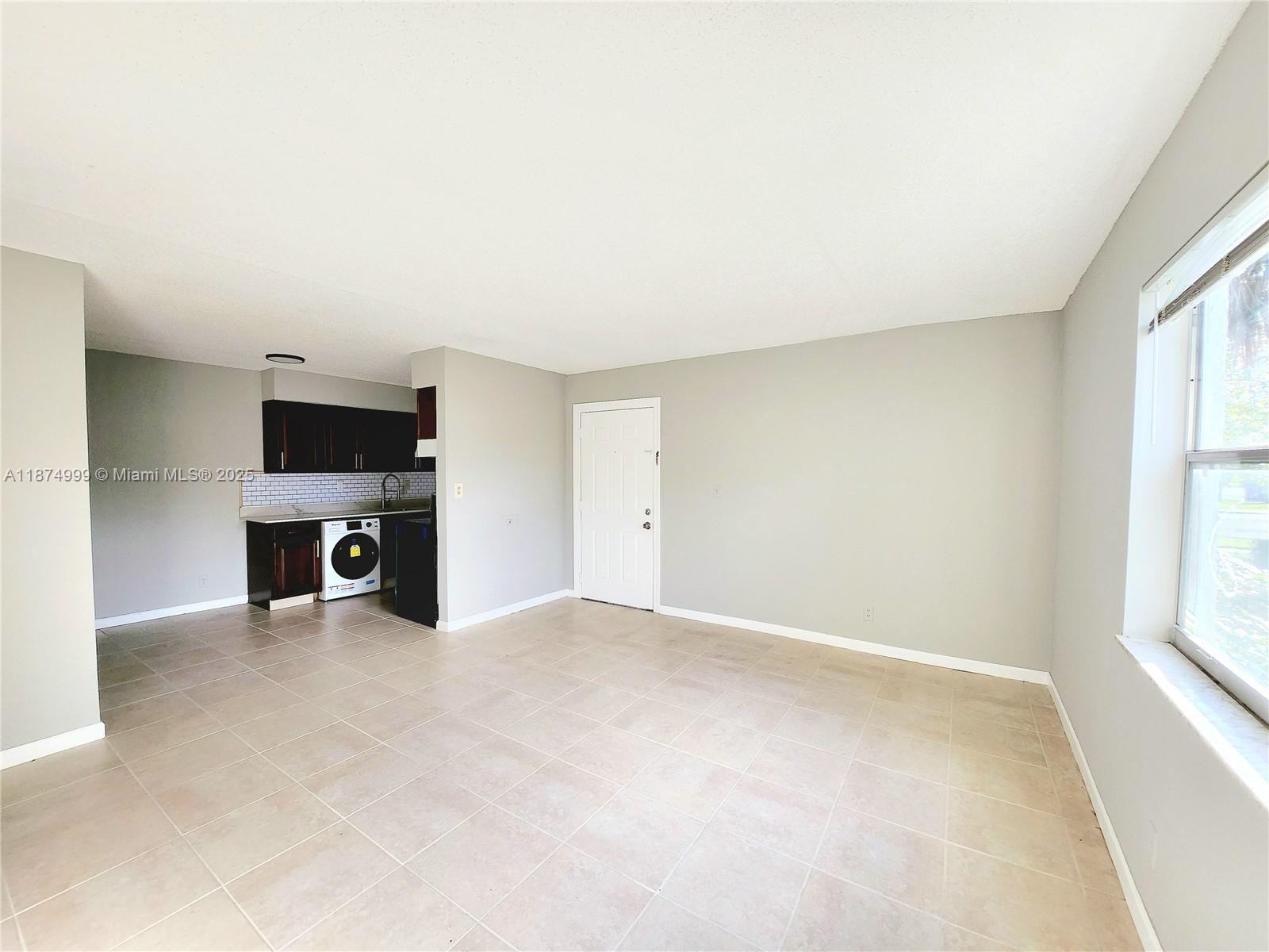191 Southwest 15th Street, Unit 201 Pompano Beach, FL 33060 - Photo 1 of 10 an empty room with a fireplace and a window