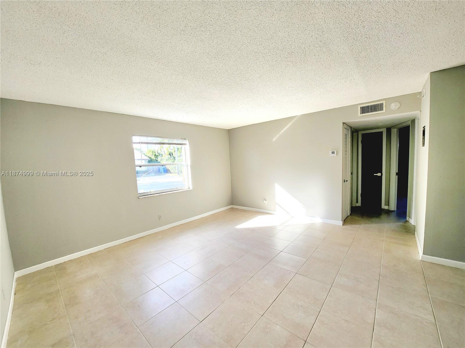 191 Southwest 15th Street, Unit 201 Pompano Beach, FL 33060 - Photo 2 of 10 a view of an empty room with a window