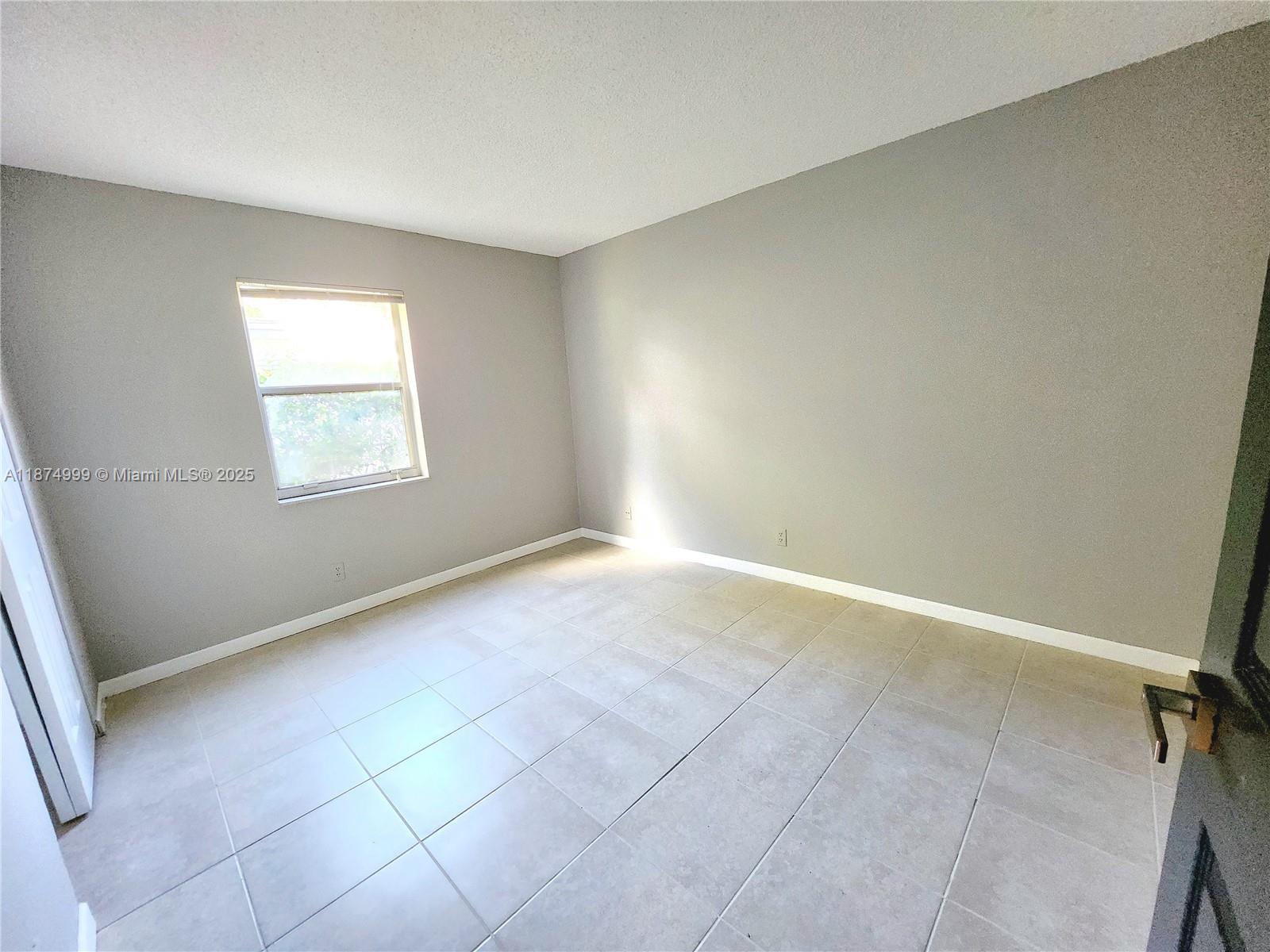 191 Southwest 15th Street, Unit 201 Pompano Beach, FL 33060 - Photo 6 of 10 an empty room with windows