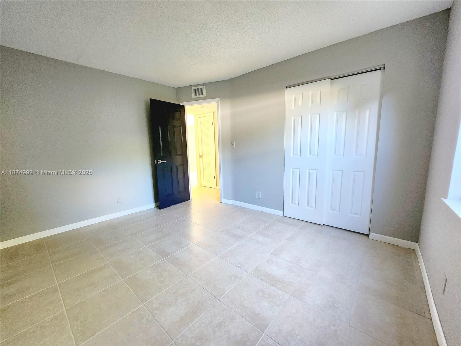 191 Southwest 15th Street, Unit 201 Pompano Beach, FL 33060 - Photo 8 of 10 an empty room with closet and a window