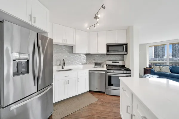 a kitchen with stainless steel appliances granite countertop a refrigerator stove microwave and sink