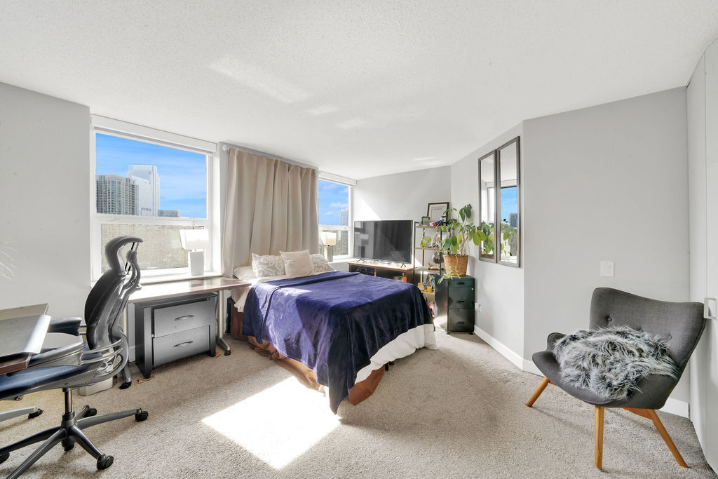 545 North Dearborn Street, Unit 2510 Chicago, IL 60654 - Photo 9 of 37 a spacious bedroom with a bed and a chair