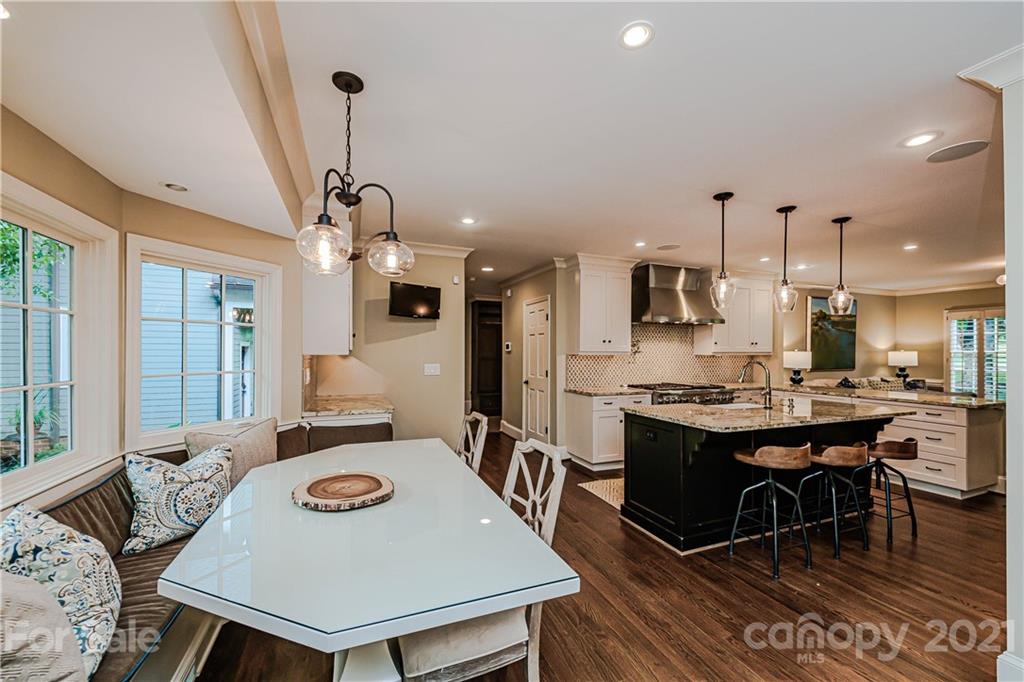 3800 River Ridge Road Charlotte, NC 28226 - Photo 10 of 48 a view of a dining room and livingroom with furniture wooden floor a rug a fireplace and a chandelier