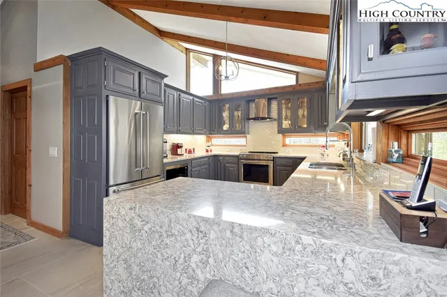 a kitchen with stainless steel appliances kitchen island granite countertop a refrigerator and a stove