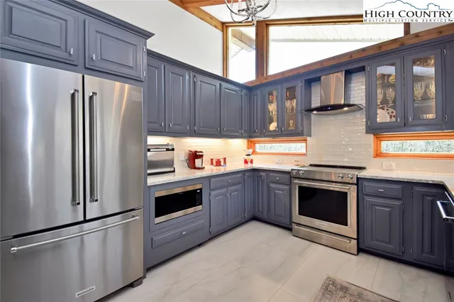 a kitchen with stainless steel appliances granite countertop a refrigerator stove and sink