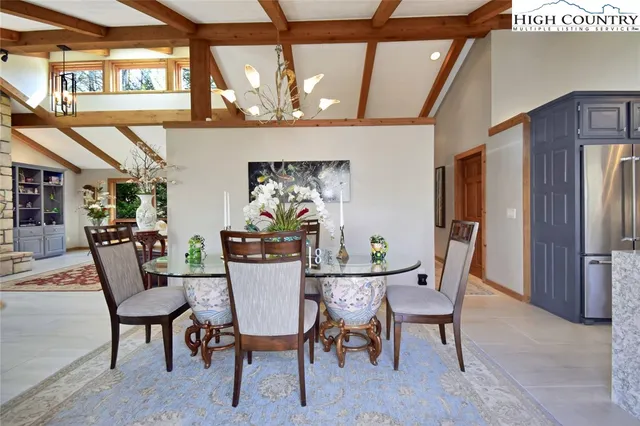 a view of a dining room with furniture a chandelier and wooden floor