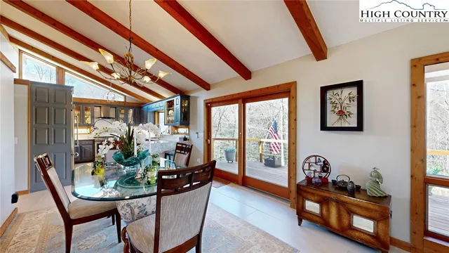 a dining room with furniture and a floor to ceiling window