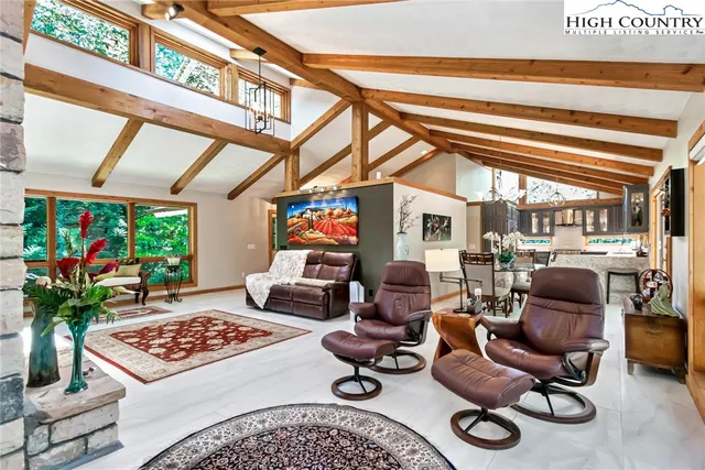 a living room with furniture a rug and a floor to ceiling window