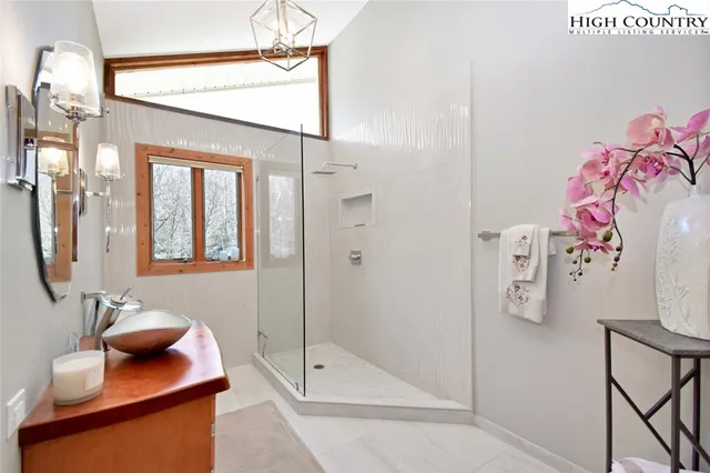 a bathroom with a bathtub shower sink and mirror