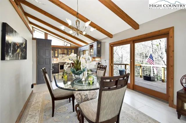 a dining room with furniture and a floor to ceiling window