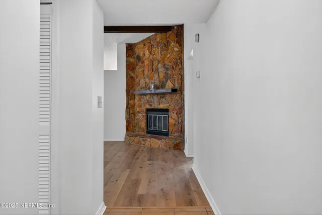 wooden floor fireplace and window in an empty room