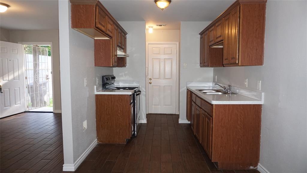 2113 R. W. Bivens Lane, Unit 2115 Fort Worth, TX 76105 - Photo 4 of 9 a kitchen with a sink cabinets and wooden floor