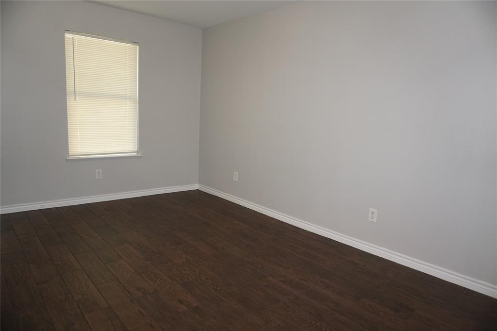 2113 R. W. Bivens Lane, Unit 2115 Fort Worth, TX 76105 - Photo 5 of 9 an empty room with wooden floor and windows