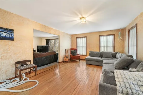a living room with furniture and a wooden floor