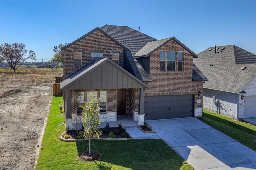 613 Brazos Drive Van Alstyne, TX 75495 - Photo 2 of 29 View of front of property with brick siding, concrete driveway, a shingled roof, and board and batten siding