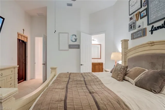 a bedroom with a large bed and a chandelier