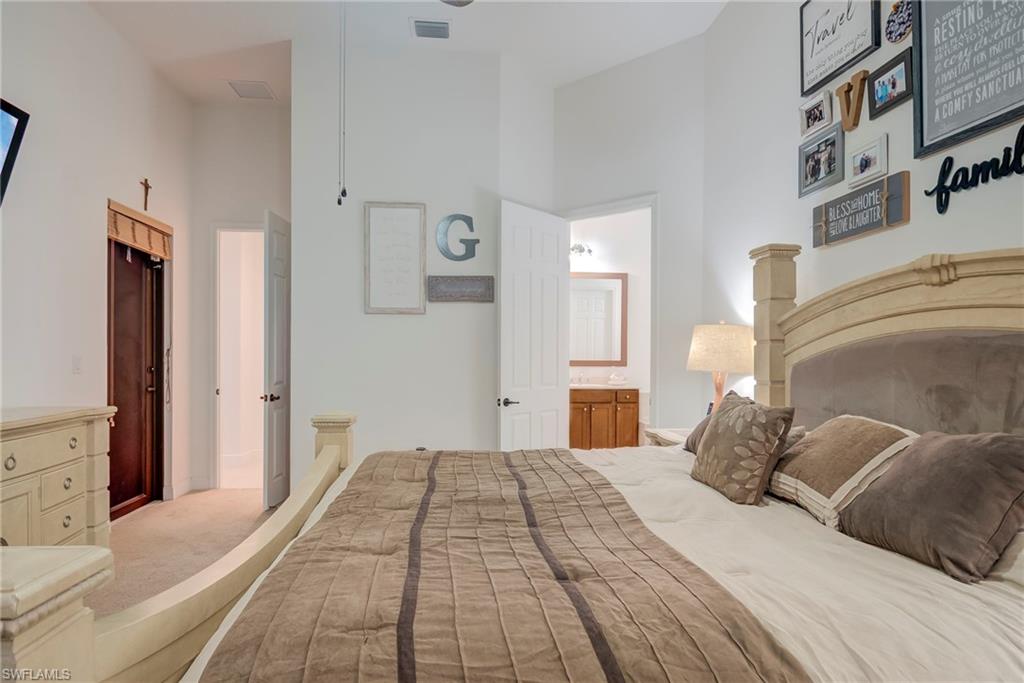 5239 Ferrari Avenue Ave Maria, FL 34142 - Photo 15 of 30 a bedroom with a large bed and a chandelier