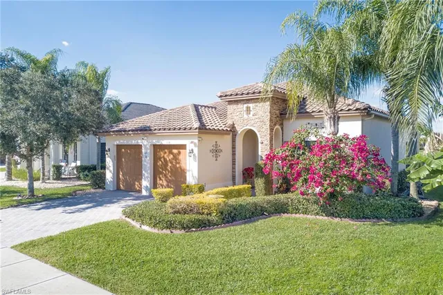 a front view of a house with a yard and potted plants