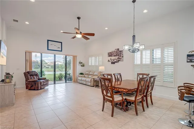 a view of a dining room and livingroom with furniture wooden floor a chandelier